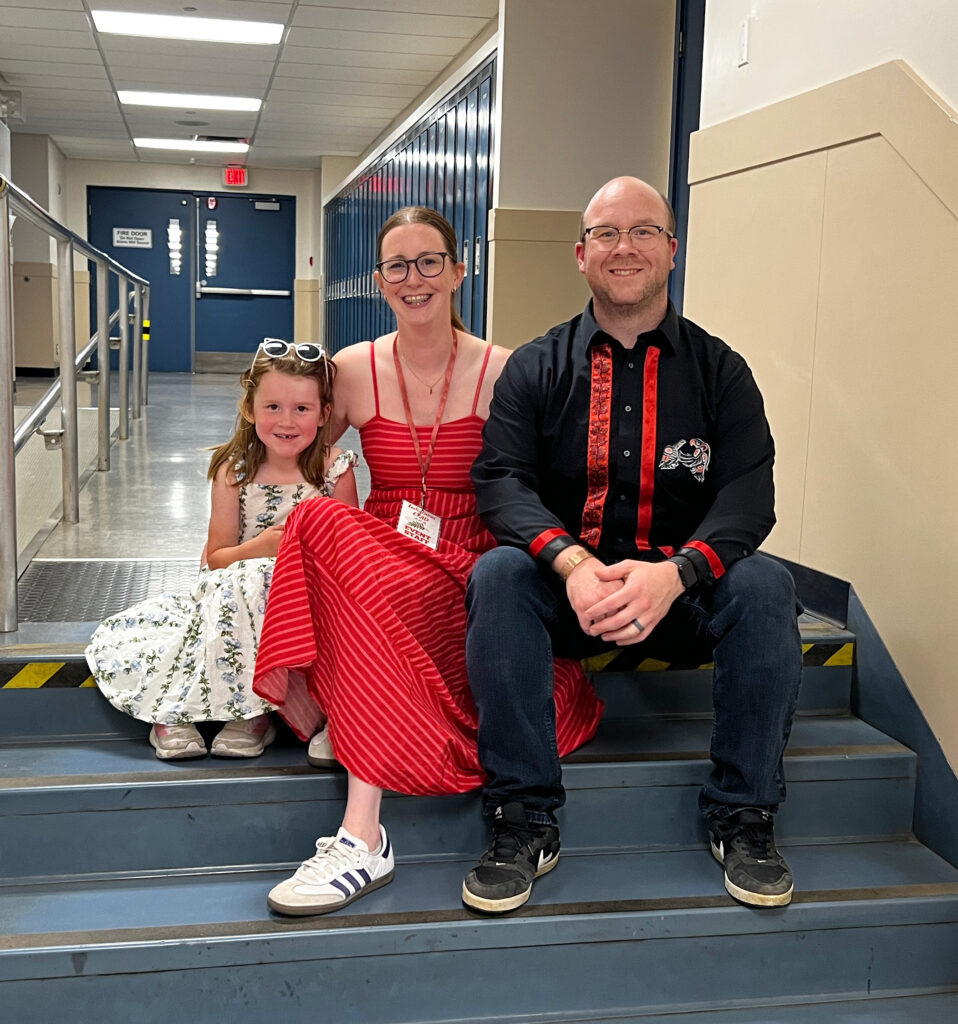 A family smiling in the hallway