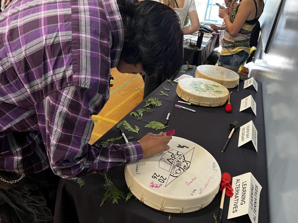 a student signing his school's drum