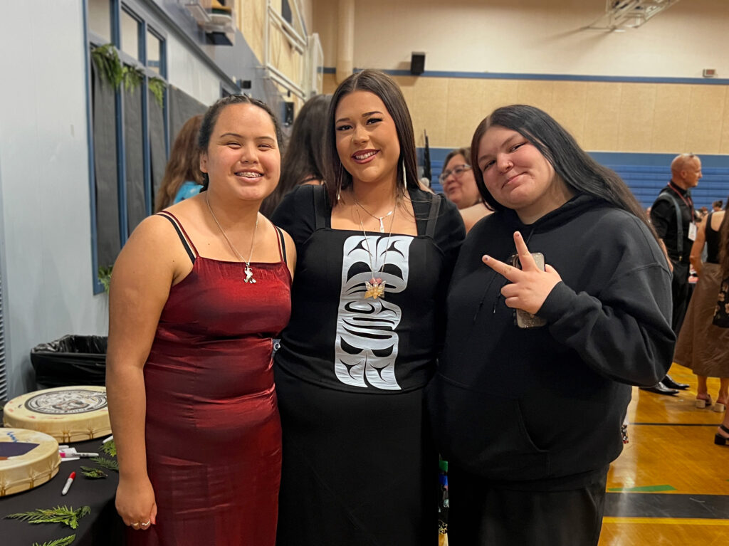 3 graduates smiling to the camera