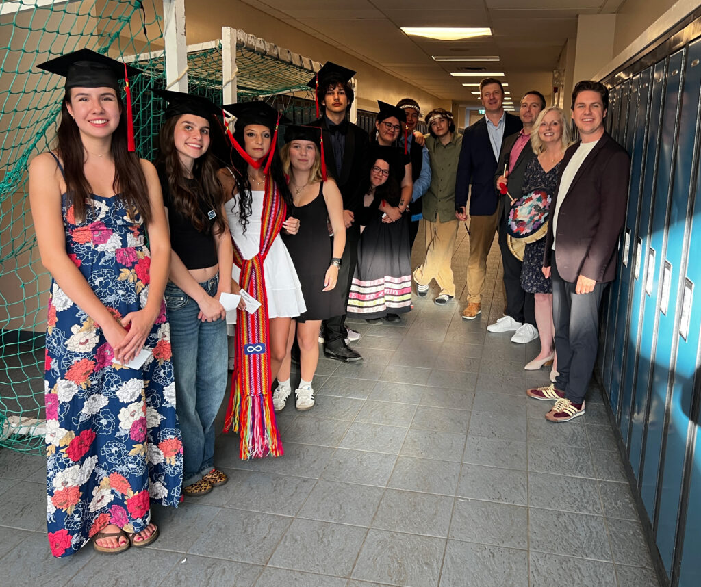 group of graduates smile to the camera